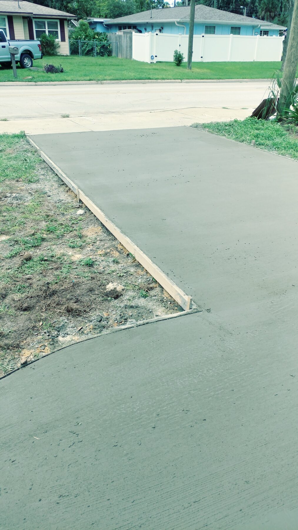 Freshly poured concrete driveway with wood forms still in place during a Central Florida residential job