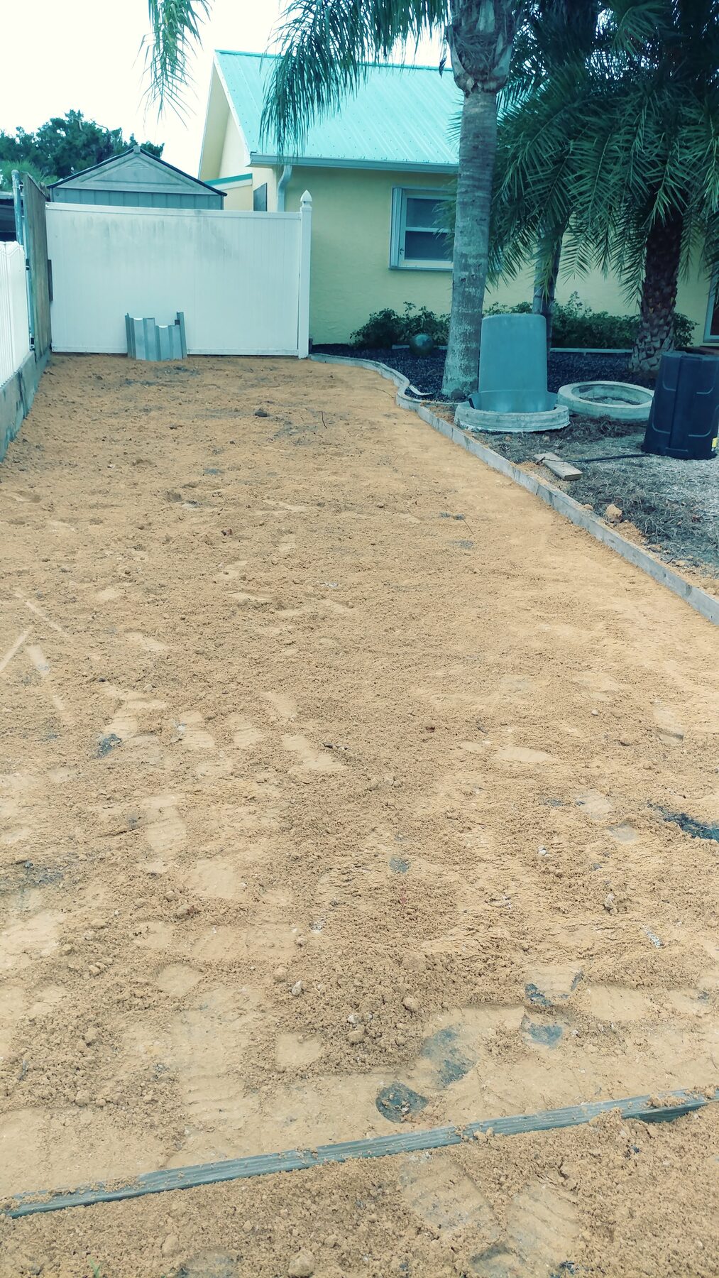 Residential driveway prep before concrete pour — graded sand pad ready for forms in Central Florida