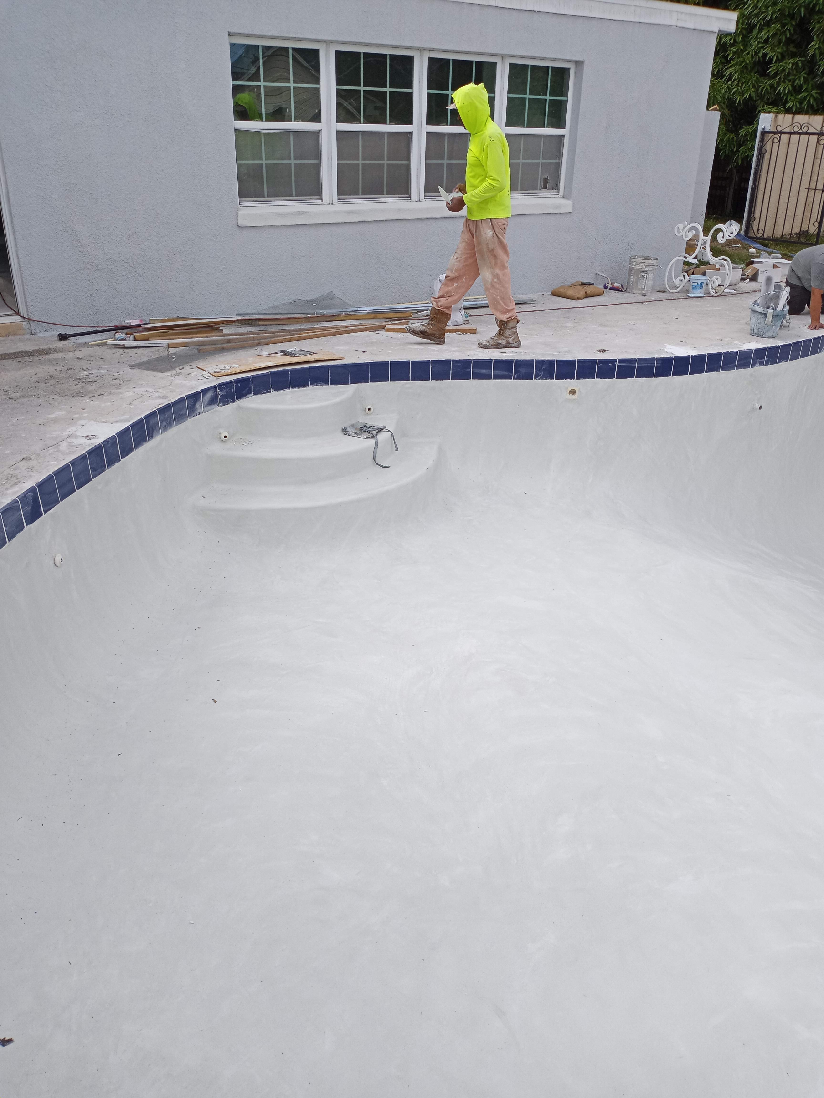 Orlando pool after replastering — fresh white plaster finish with new blue waterline tile
