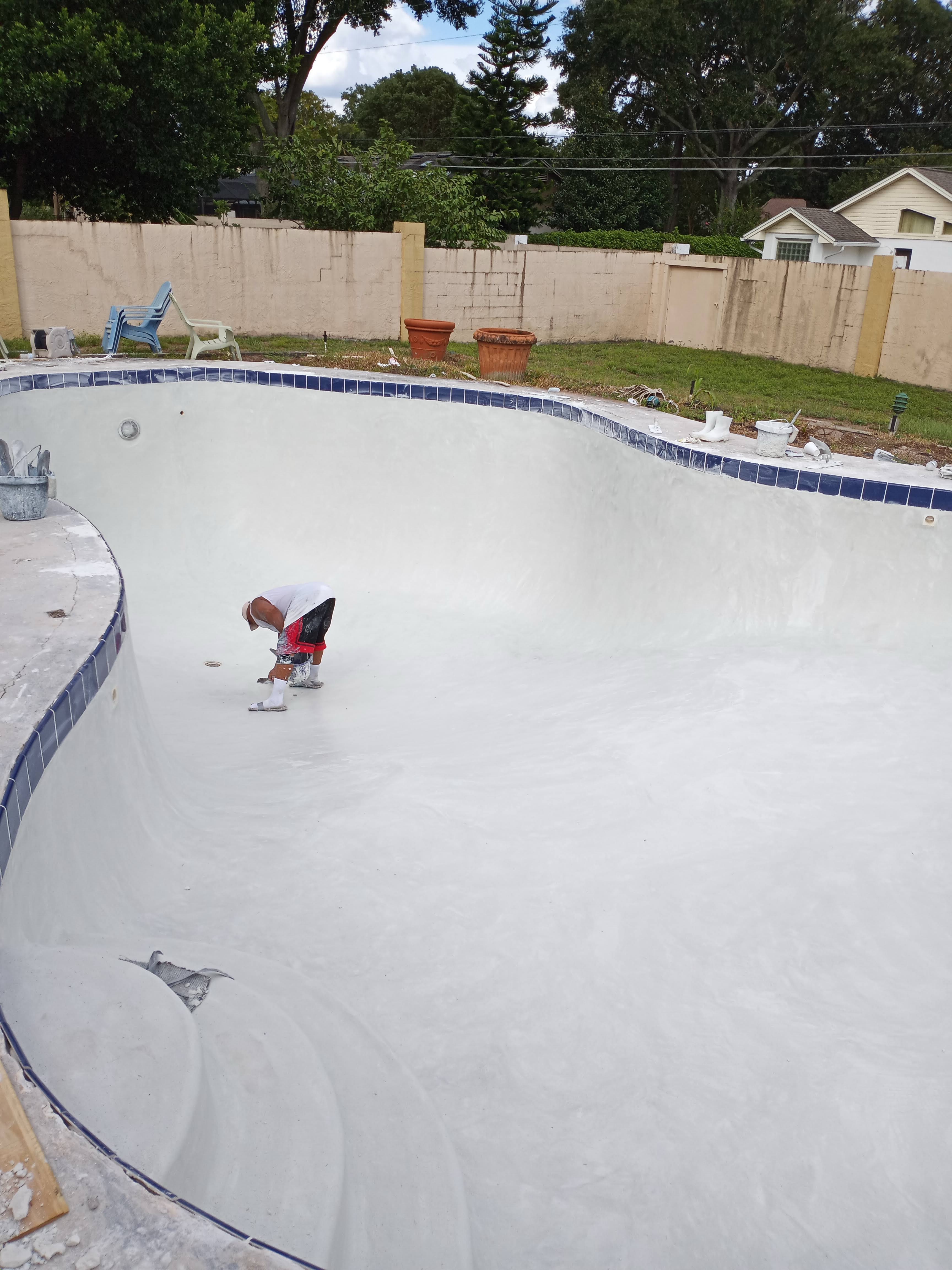 Wide view of completed Orlando pool plastering job with smooth white interior finish