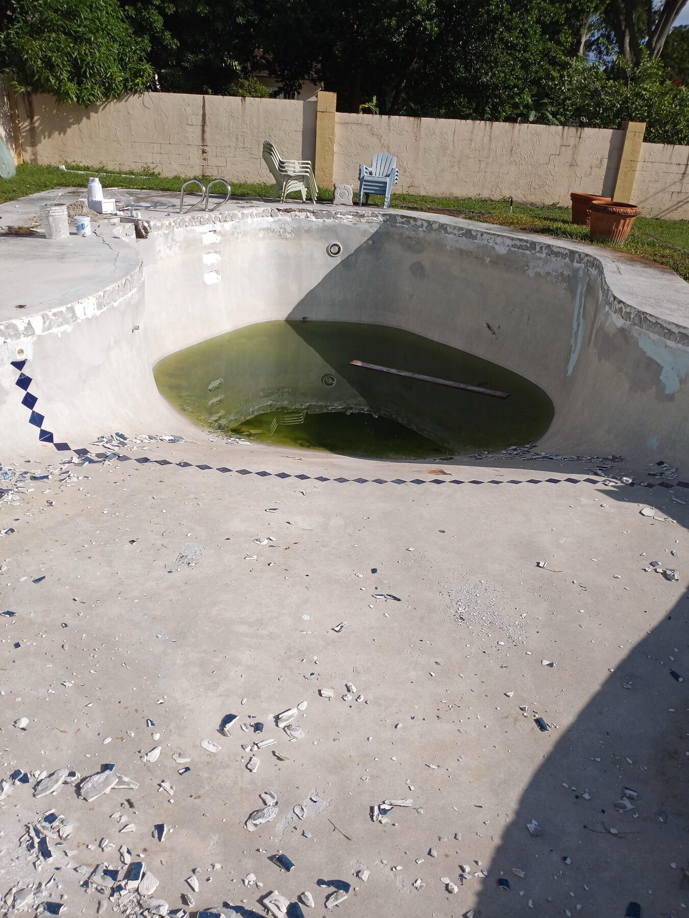 Orlando pool during chip-out — old plaster removed, gunite shell exposed